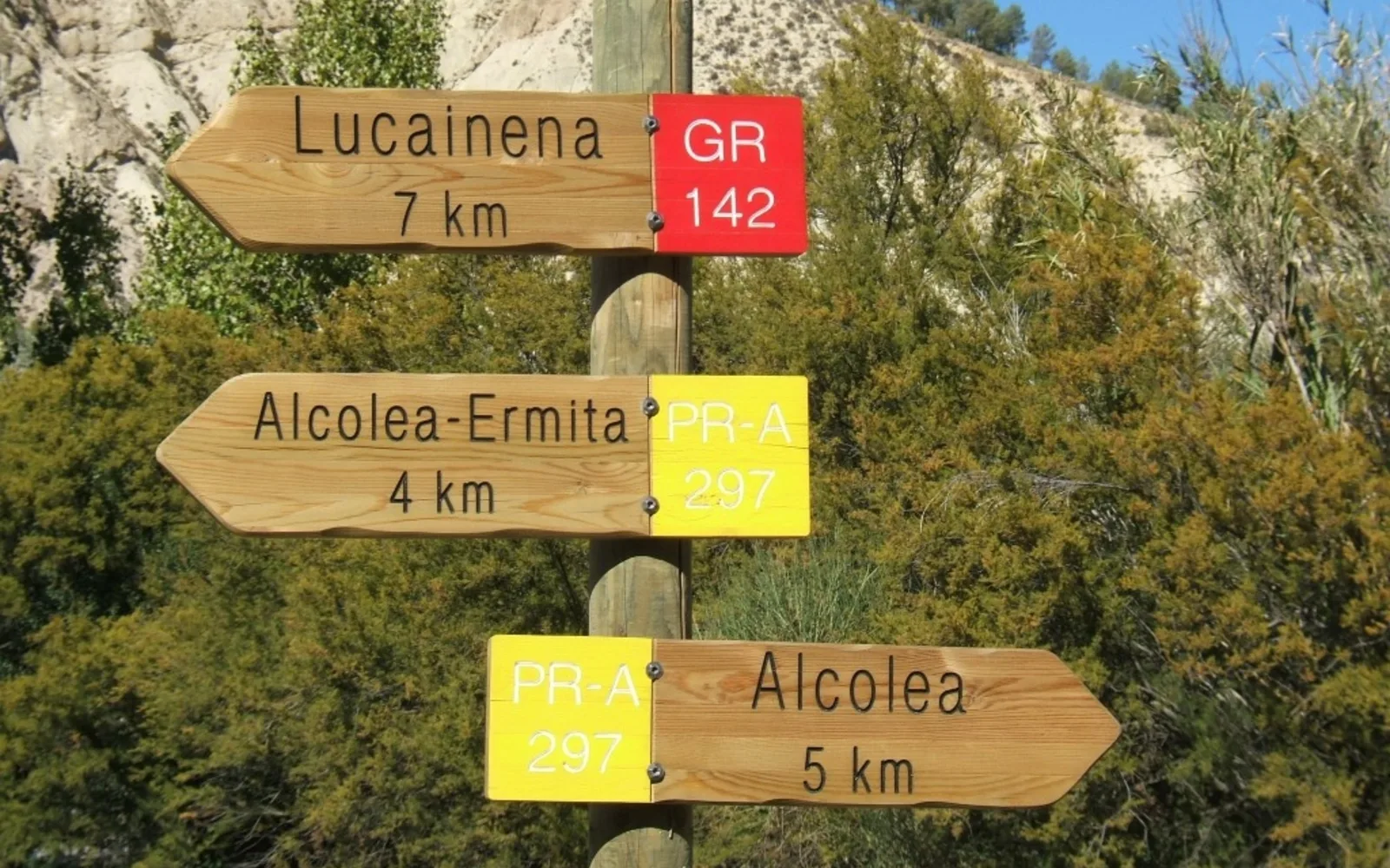 Trail marker and signage on a hiking path in a mountain landscape
